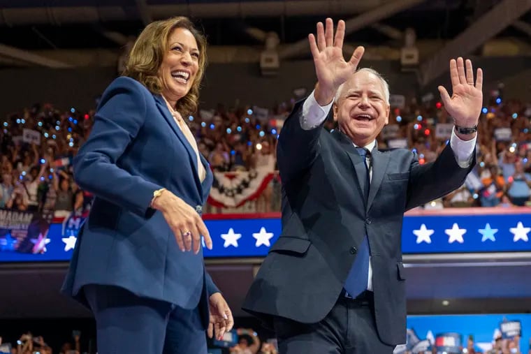 Vice President Kamala Harris and her running mate, Minnesota Gov. Tim Walz, take the stage at a campaign rally at Temple University's Liacouras Center Tuesday.