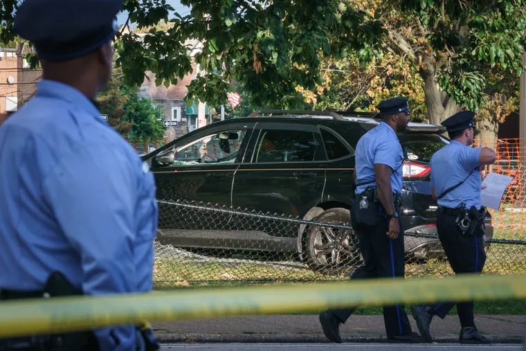 Police near a vehicle that was part of the crime scene on on Ryan Avenue near Lincoln High School on Monday. Two people were shot just after school dismissed. Jeffrey Carter, 66, later succumbed to his injuries.
