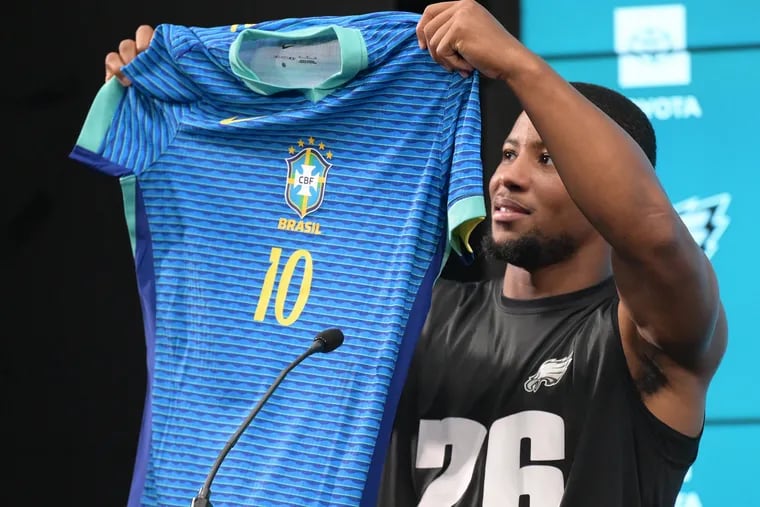 Eagles running back Saquon Barkley shows of his customized Brazil soccer jersey on Thursday.