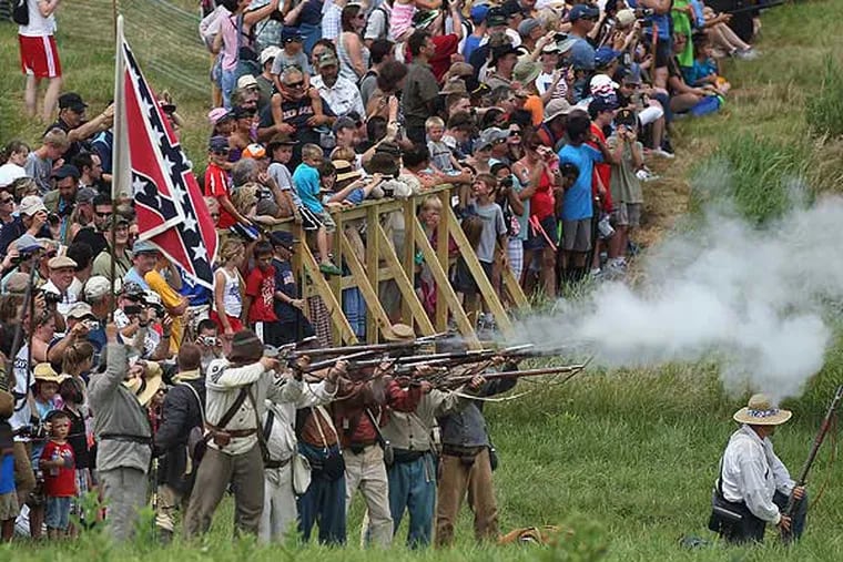 With hundreds of spectators looking on, reenactors from General Henry Heth's infantry fire into the Union infantry during a squirmish showing the first day of battle. First day of the battle of Gettysburg is represented bya squirmish between Union Genearl John Buford and Confederate General Henry Heth. 150th Gettysburg Anniversary national Civil War Battle Reenactment held at The Redding Farm in Gettysburg on Thursday, July 4, 2013. (MICHAEL BRYANT / Staff Photographer)