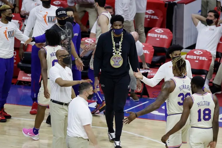 Sixers center Joel Embiid and guard Ben Simmons greet their teammates.