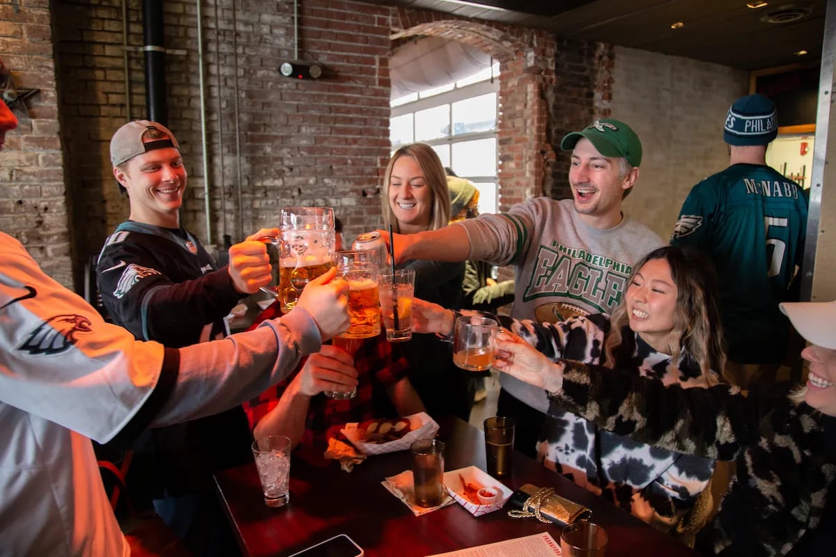 Eagles fans cheer their drinks during an Eagles game watch party at Frankford Hall beer garden in Fishtown, Philadelphia.