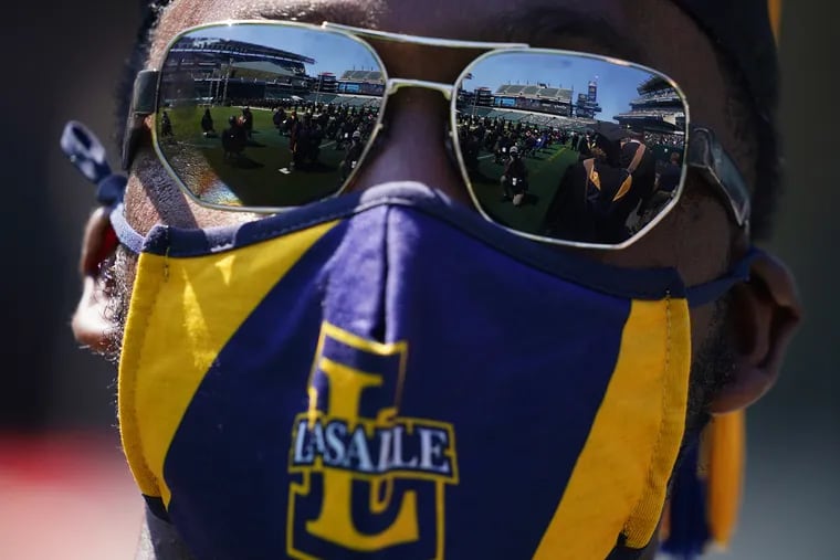 Lincoln Financial Field is reflected in sunglasses worn by Samir Inge as he waits to walk onto the stage during La Salle University's Class of 2021 commencement at the stadium in South Philadelphia on May 15. Inge was receiving his MBA.