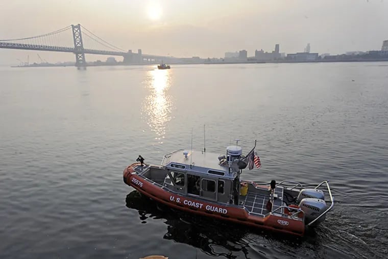 A U.S. Coast Guard boat cruises the Delaware River near Penn's Landing.