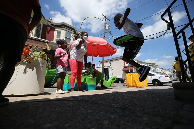 Adrianna Carter (left), a neighbor, turns a jump rope for Shyion Charles, 9, during a Playstreets event on 200 block of S. Alden St in Philadelphia, Pa. on July 28, 2020.
