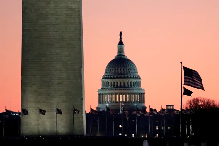 The U.S. Capitol building, center, is seen next to the bottom part of the Washington Monument, left, before sunrise on Capitol Hill in Washington, Thursday, Dec. 19, 2019.