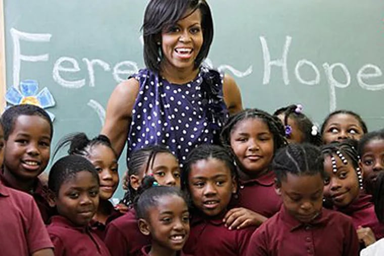 First lady Michelle Obama, posing with some third-grade students, has been generally praised for smart decisions about clothing that looks best on her. (AP Photo / Manuel Balce Ceneta / File)