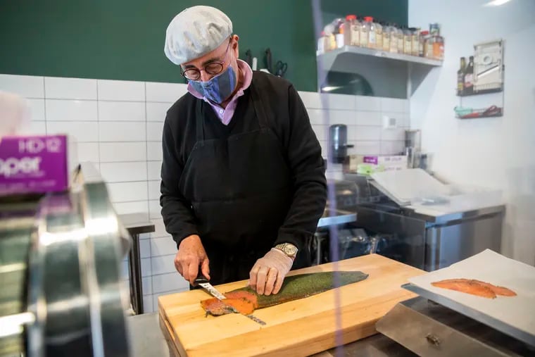 Gene Mopsik slices gravlax at Biederman's Specialty Foods, an appetizing shop near the Italian Market in South Philadelphia.