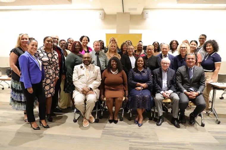 Camden school Superintendent Katrina McCombs (seated, third from left) and Rowan University officials kicked off the Teach Camden program for 19 paraprofessionals hoping to become certified teachers.