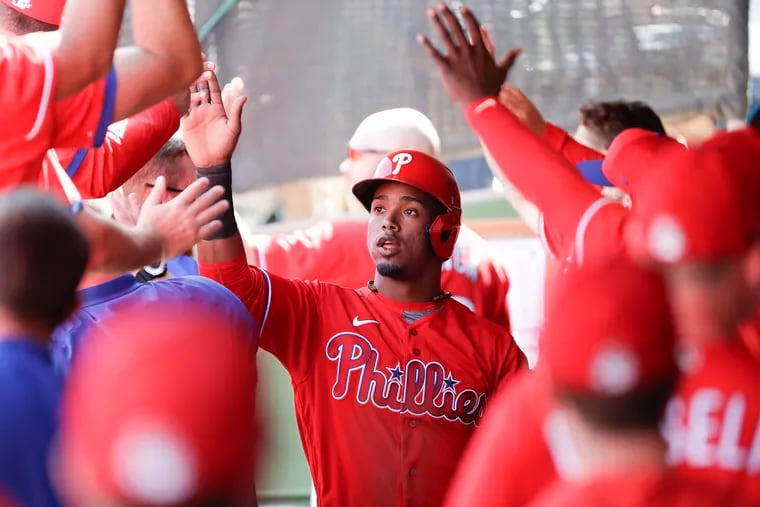 Phillies Jean Segura high-fives his teammates after scoring a run against the Pittsburgh Pirates in a spring training game at  on Sunday.