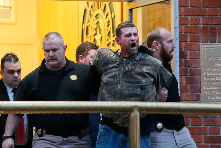 In this Thursday, Feb. 28, 2019, photo, Gordon Wayne Coble is led out of the of the Texas State Penitentiary in Huntsville, Texas, after reacting to the execution of his father, Billie Wayne Coble. Chaos erupted outside Texas' death chamber Thursday night when the son of the condemned inmate pounded on the chamber windows, shouted obscenities, and threw fists after his father spoke his final words. (Jerry Larson / Waco Tribune-Herald via AP)