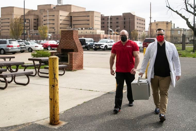 Dr. Kevin Emmons of Rutgers (right) walks in with a case of more doses of the Johnson & Johnson COVID-19 vaccine after running out during a pop-up vaccine clinic at the Mickle Towers housing complex in Camden, NJ on Friday, April 02, 2021. Dr. Emmons has been part of New Jersey's pandemic response since last year, when he ran a field hospital in Atlantic City. Now he's running a series of pop-up clinics to get underserved residents vaccinated.