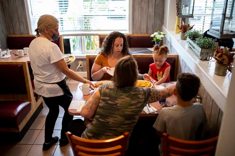 Clockwise from left, Lakeside Diner owner Debbie Brindisi brings food for Cherish Moscagiuri, her two kids Elliana Moore and Travis Moore, and Lauren Brousell, in Lacey Township, N.J., on Tuesday.