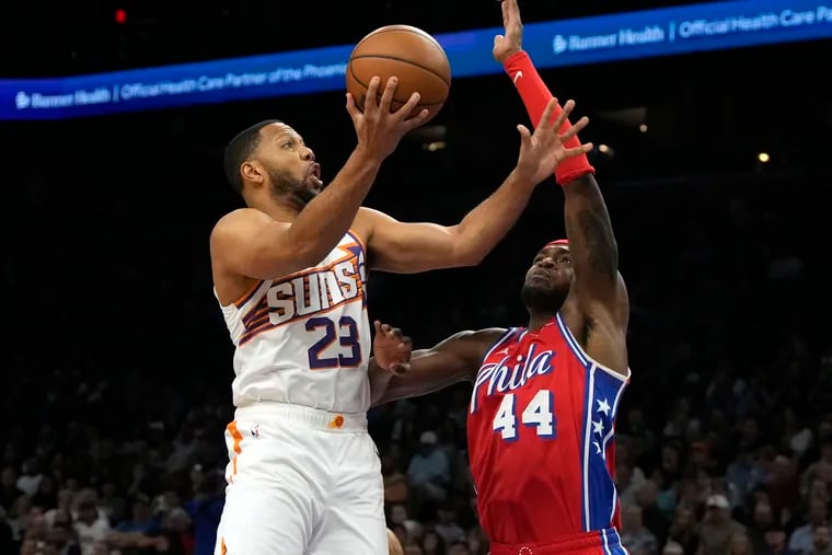 Phoenix Suns guard Eric Gordon drives against Sixers forward Paul Reed during an NBA game.