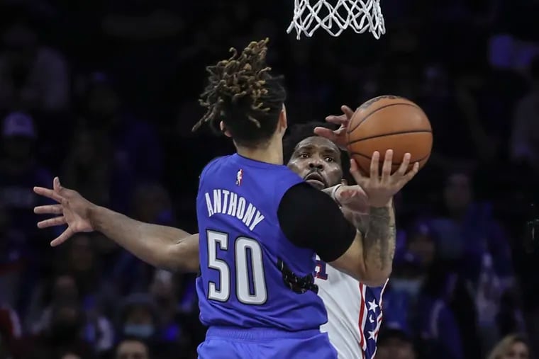 Sixers Joel Embiid blocks the shot of Magics Cole Anthony  during the 4th quarter at the Wells Fargo Center in Philadelphia, Wednesday,  January 19, 2022. Sixers bested  the Magic 123-110