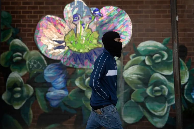 A pedestrian wears a balaclava ski mask to shield from the cold air along Columbus Boulevard in Philadelphia, on Monday, Jan. 11, 2021. (Jose F. Moreno/The Philadelphia Inquirer via AP)