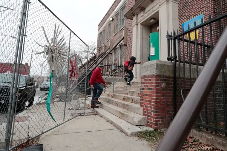 Parents and children navigate temporary fences and support beams that are holding up the second floor of Vare Recreation Center in South Philadelphia. The facility is set to get a $14 million renovation as part of the city’s Rebuild program.