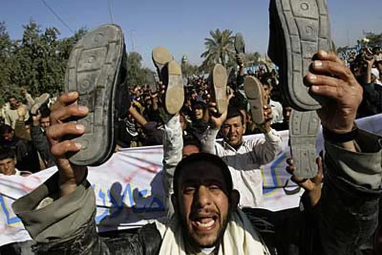 Iraqis raise their shoes as hundreds demanded a release for Iraqi journalist Muntadhar al-Zeidi who threw his shoes at US President George W. Bush in Kufa, Iraq, Friday. Dec. 19, 2008.  (AP)