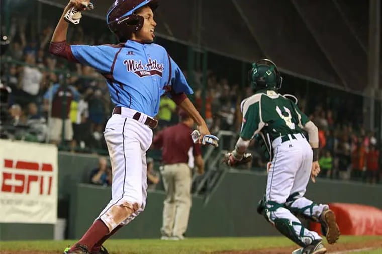 Taney's Scott Bandura exults after sliding home with a run during the Little League World Series in 2014.
