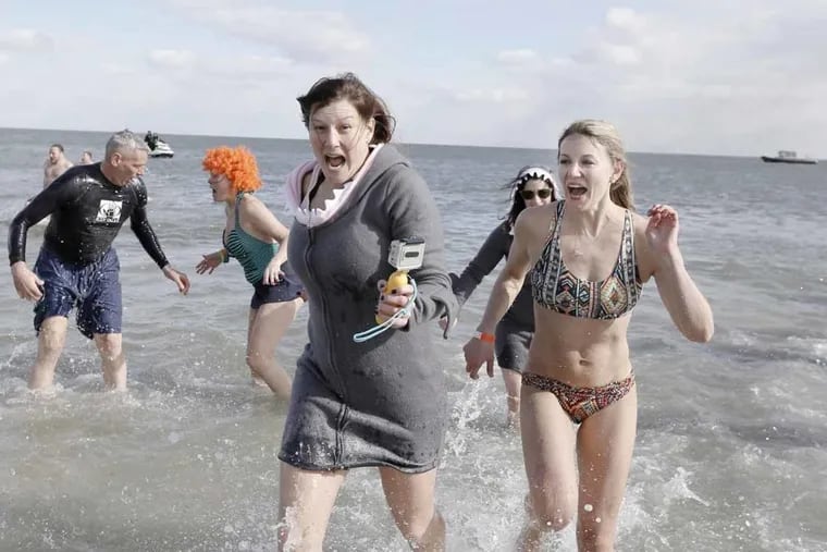 File Photo: Participants react after taking part in Sea Isle City’s polar bear plunge in February 2013. The deep freeze gripping the region is prompting organizers to cancel New Year’s Day plunges   at the Shore.