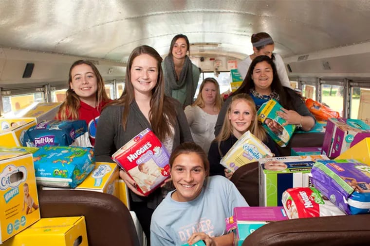 Girls from Faith Irons' child development class at Haverford High School made it their mission to collect a busload of new baby diapers after reading a recent Inquirer article. The drive collected more than 33,000 diapers. The class donated 500 diapers to each of 13 needy families identified by a school social worker. On Monday, seniors Carolyn Donohue (center left) and Rachel Bova (center right) were among classmates who distributed donated diapers to Cradles to Crayons in Conshohocken and Amnion Crisis Pregnancy Center in Upper Darby.