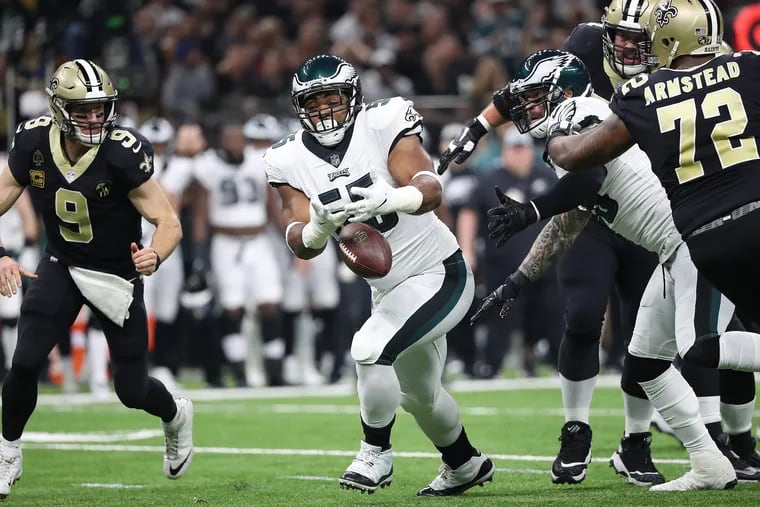 Brandon Graham (center) tries to grab a loose ball as the Saints' Drew Brees watches during the Eagles' loss in the playoffs to New Orleans. Graham agreed to a contract extension on Friday, but that doesn't mean the Eagles won't look into a deep draft class.