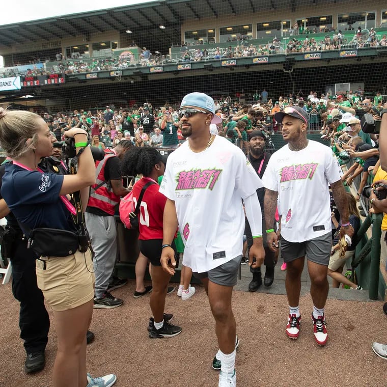 Jalen Hurts, left, and Shaun Bradley enter the field for DeVonta Smith's celebrity softball game and home run derby at Coca-Cola Park in Allentown on Saturday.