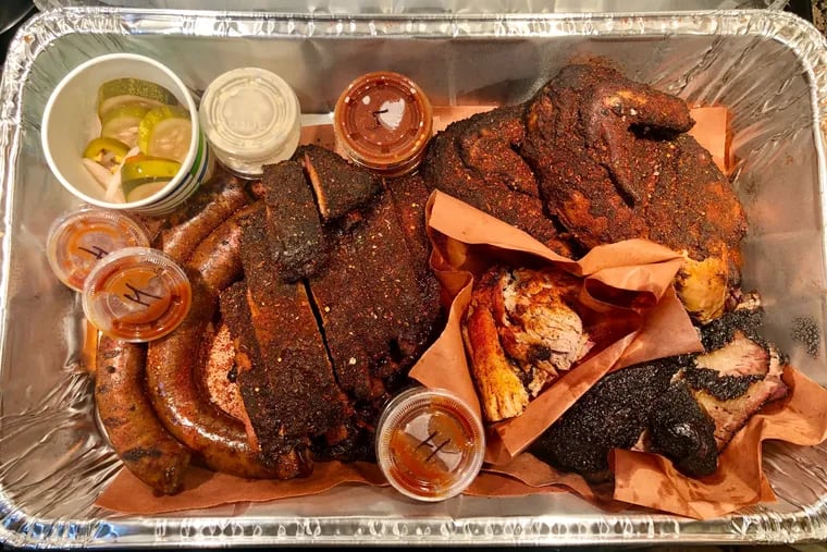 An assortment of smoked meats from the Lucky Well's new Spring Arts location includes (from left) smoked sausage, dry-rubbed St. Louis cut ribs, pulled pork, a whole chicken, and brisket.