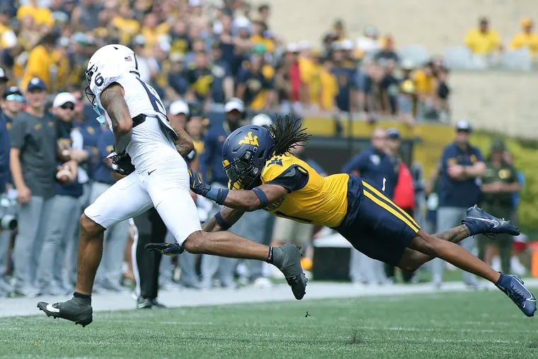 Penn State wide receiver Harrison Wallace III pulls in a pass as West Virginia cornerback Garnett Hollis Jr. moves in Saturday.