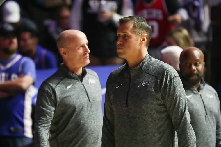 Sixers assistant coach Dave Joerger, center, stands during player introductions before a game between the Sixers and Pacers.