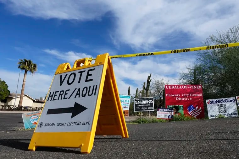 FILE - A voting sign points voters in the right direction to drop off ballots in Phoenix, Monday, Nov. 7, 2022.