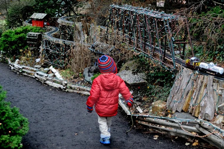 A youngster watches the popular Holiday Garden Railway made with logs and branches used to create unique tunnels and overhead trestles. at Morris Arboretum in December 4, 2014 file photo.