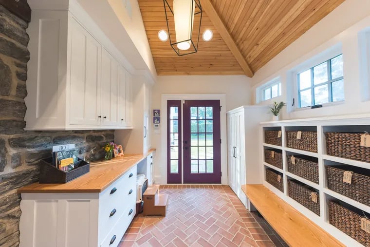 The ceiling of this mudroom got an upgrade with a tongue-and-groove wood feature designed by Down2Earth Interior Design.