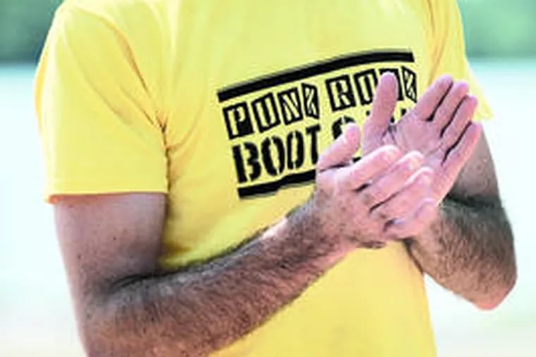 A participant wearing his Punk Rock Workout tee shirt applauds the instructor after a session.