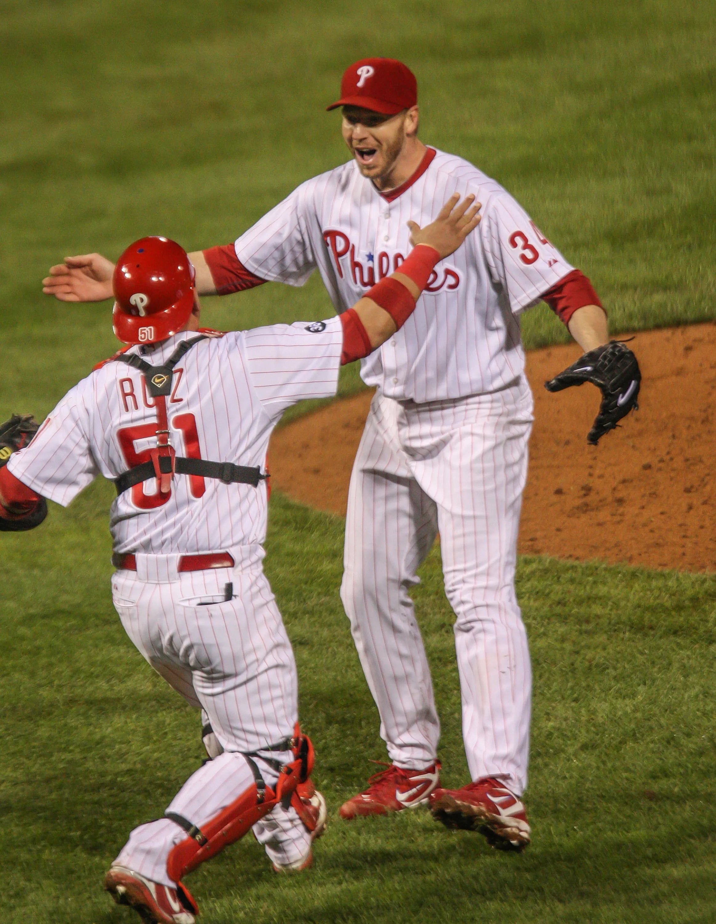 Phillies catcher Carlos Ruiz (51) runs up to hug pitcher Roy Halladay (34) after the last out in the ninth inning of their first National League Division Series game against the Cincinnati Reds at Citizens Bank Park on Oct. 6, 2010. Halladay pitched a no-hitter, and the Phillies won 4-0.