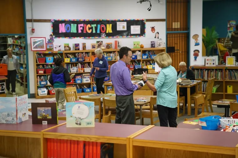 Teachers and students use the library at the John B. Kelly School.