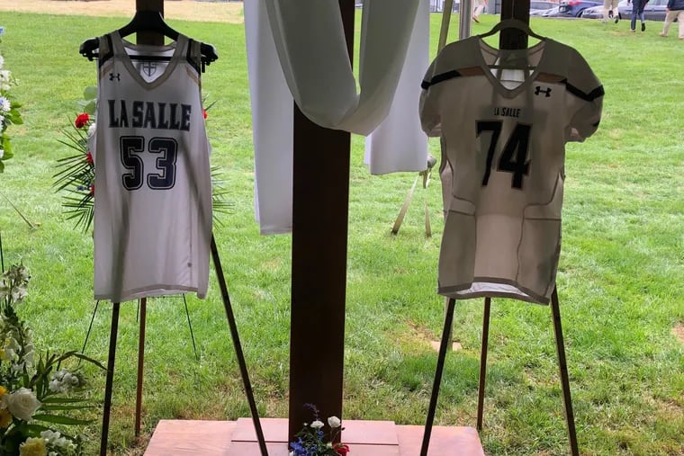 Isaiah Turner's La Salle College High School basketball and football jerseys beneath a cross.
