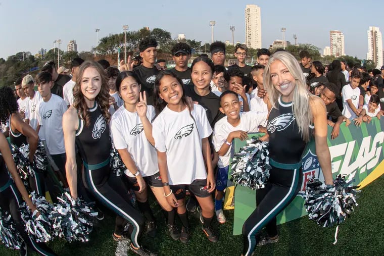 Eagles cheerleaders pose for a photo with Brazilian children during a football clinic in São Paulo, Brazil.