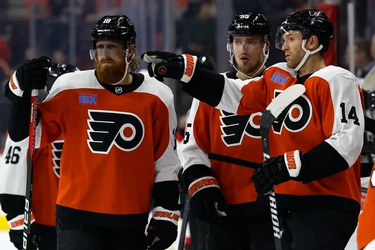 Flyers center Sean Couturier (R) goes over positioning with defensemen Rasmus Ristolainen and Marc Staal (L) during a preseason game against the New Jersey Devils in September.