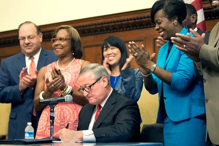 City Council members applaud as Mayor Jim Kenney signs the soda-tax bill at City Hall in a 2016 ceremony.