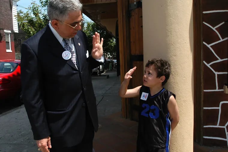 Philadelphia at-large City Council candidate Juan Ramos greeting Carlos Rivas, 5, outside the Tierra Colombiana Restaurant on Fifth Street in Philadelphia in 2003.