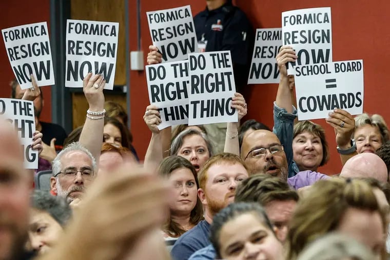 Residents protest at the Souderton school board meeting Thursday as the board continues to face demands that Bill Formica resign after making a lewd social media post about Kamala Harris.