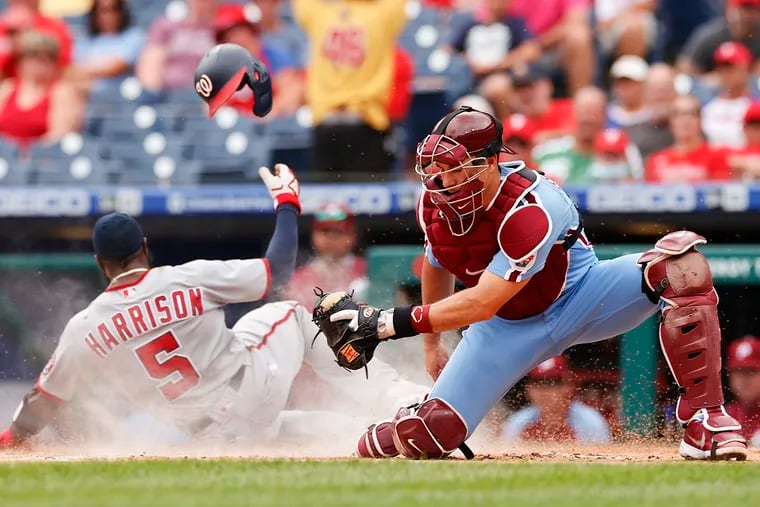 Washington Nationals Josh Harrison scores on a sacrifice fly ball past Phillies  J.T. Realmuto.