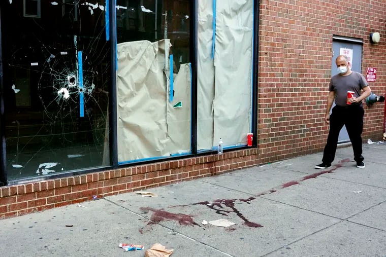 A person walks past the scene of a fatal overnight shooting on South Street on Sunday.