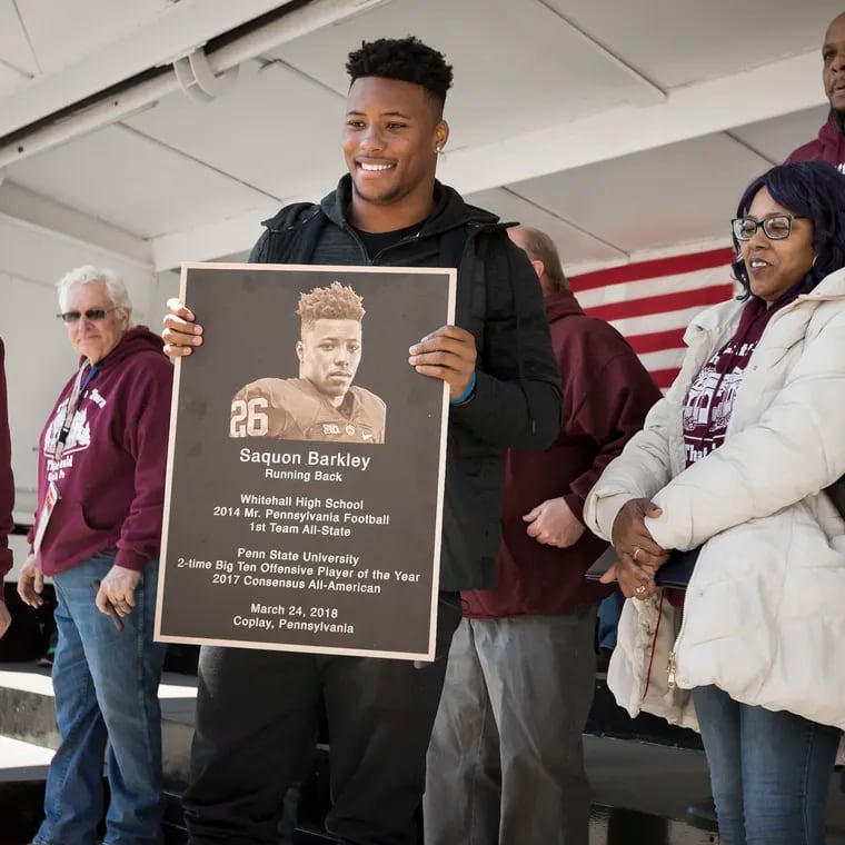 Former Penn State running back Saquon Barkley holds a plaque as he is honored by his hometown of Coplay, Pa., on Saquon Barkley Day, March 24, 2018. His parents, Tonya Johnson and Alibay Barkley, watch.