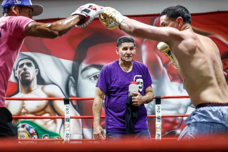 Danny Garcia trains for his middleweight title fight with cornerman Wahid Rahim (left) as Angel Garcia keeps a watchful eye.