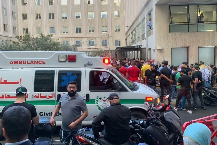 People gather outside the American University hospital after the arrival of several men who were wounded by exploding handheld pagers Lebanon on Tuesday, Sept. 17, 2024.