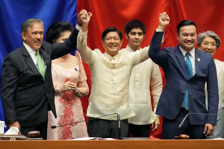 President-elect Ferdinand "Bong" Marcos Jr., center, raises hands with Senate President Vicente Sotto III, left, and House Speaker Lord Allan Velasco during his proclamation at the House of Representatives in Quezon City, Philippines on Wednesday.