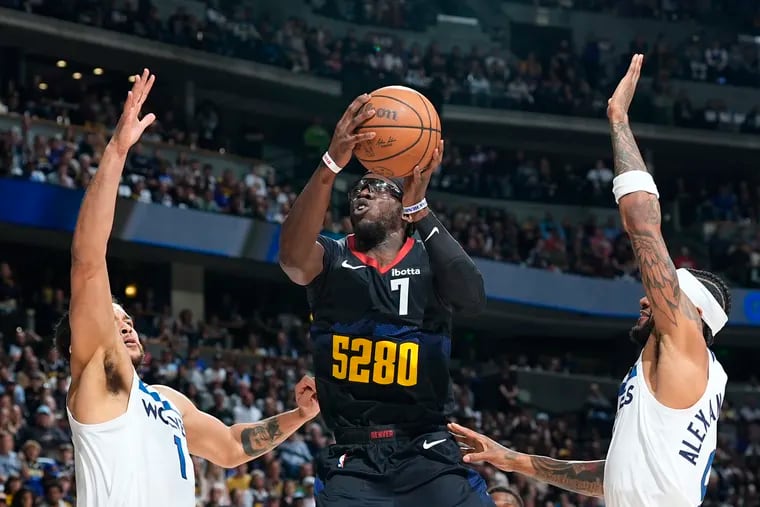 Denver Nuggets guard Reggie Jackson drives to the basket between Minnesota Timberwolves forward Kyle Anderson (left) and guard Nickeil Alexander-Walker during a May 6 playoff game.