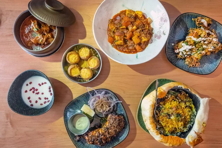 A selection of signature dishes from Unapologetic Foods. Upper left: Junglee maas goat curry, dahi batata puri, paneer khurchan, and kale pakoda. Bottom: Raita, bhatti da murgh, and lucknow dum biryani.